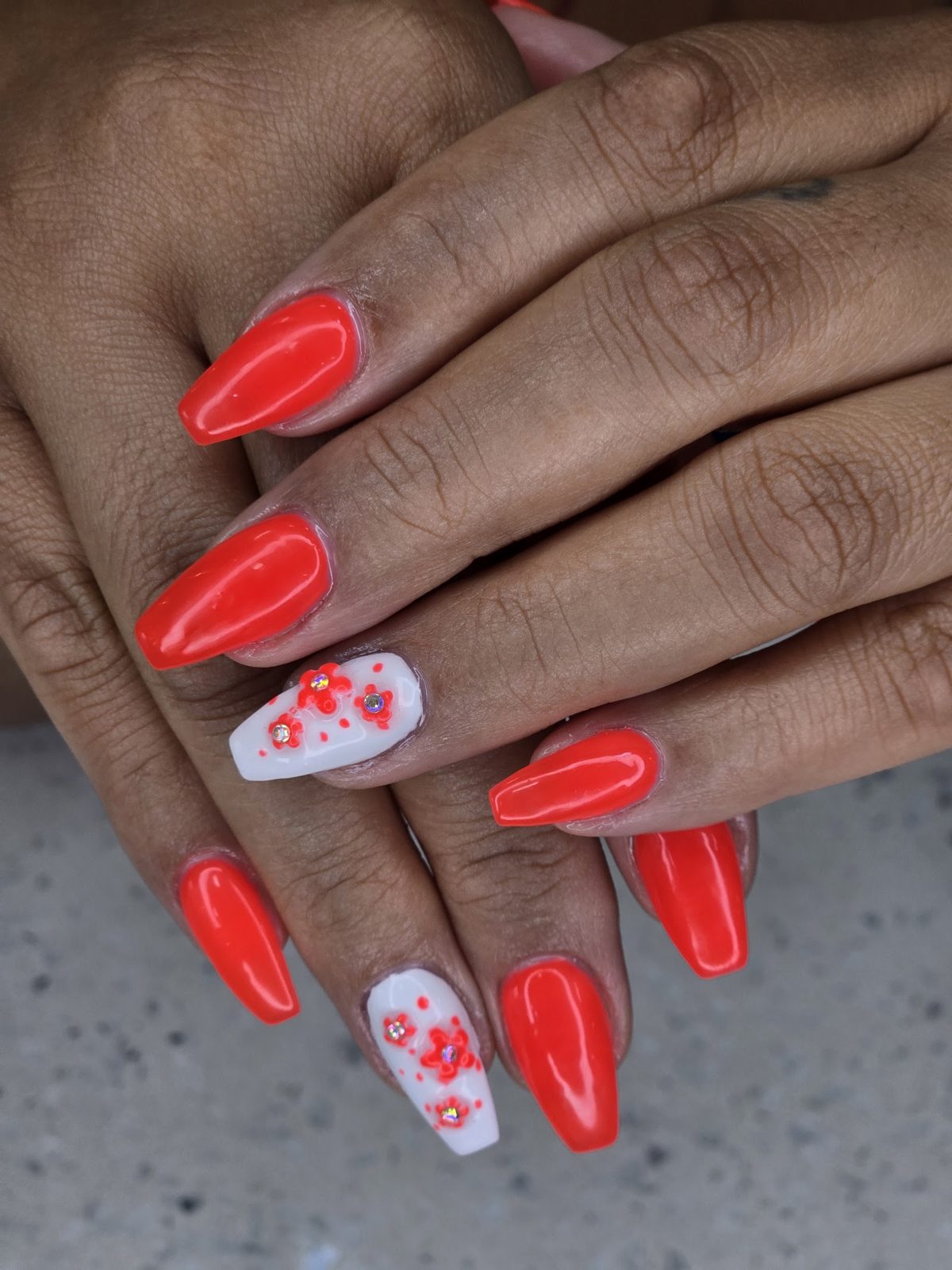 Red gel nails with floral art done at the Maya's nail bar